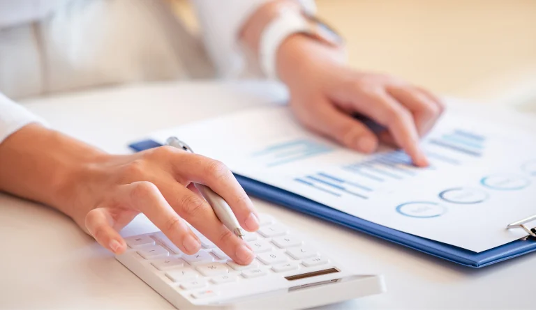 Une personne effectuant un calcul a l'aide de graphique et d'une calculatrice.