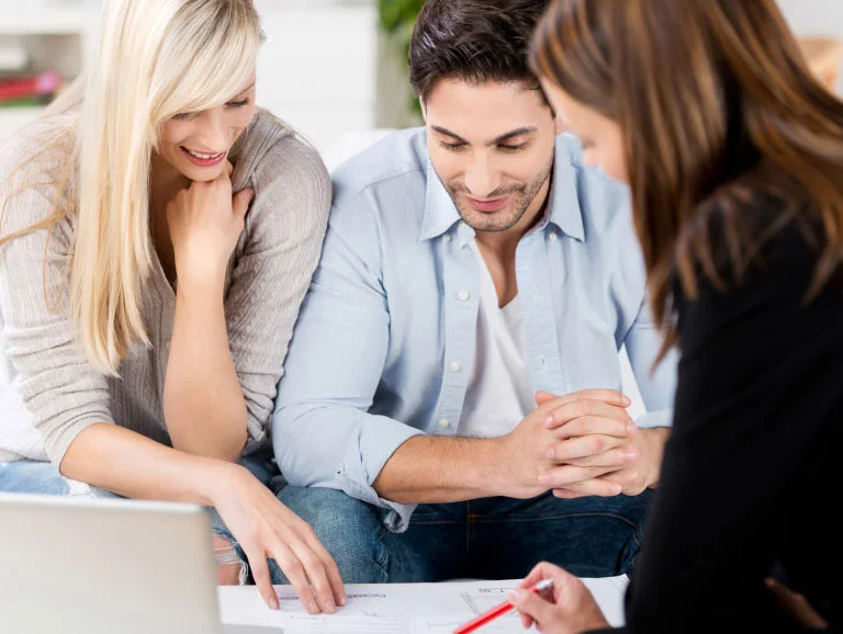 Couple examinant un plan avec l'aide d'une conseillere.