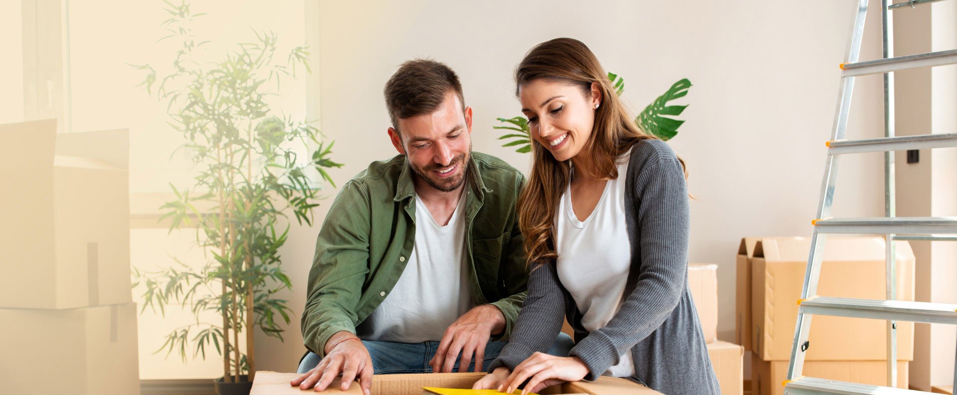 Couple heureux vidant une boite de demenagement.